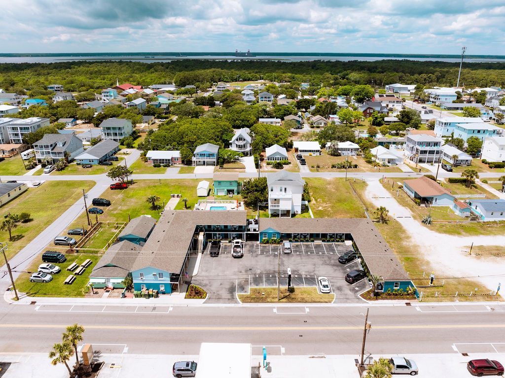 An aerial view of Seabirds Motel at Kure Beach, showing the surrounding neighborhood and proximity to the ocean. The image showcases the motel's prime location for a pet-friendly stay in North Carolina.