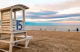 A serene beach scene near Seabirds Motel at Kure Beach featuring a lifeguard chair and a peaceful shoreline. This image captures the tranquil setting available to guests, enhancing their pet-friendly stay in North Carolina.