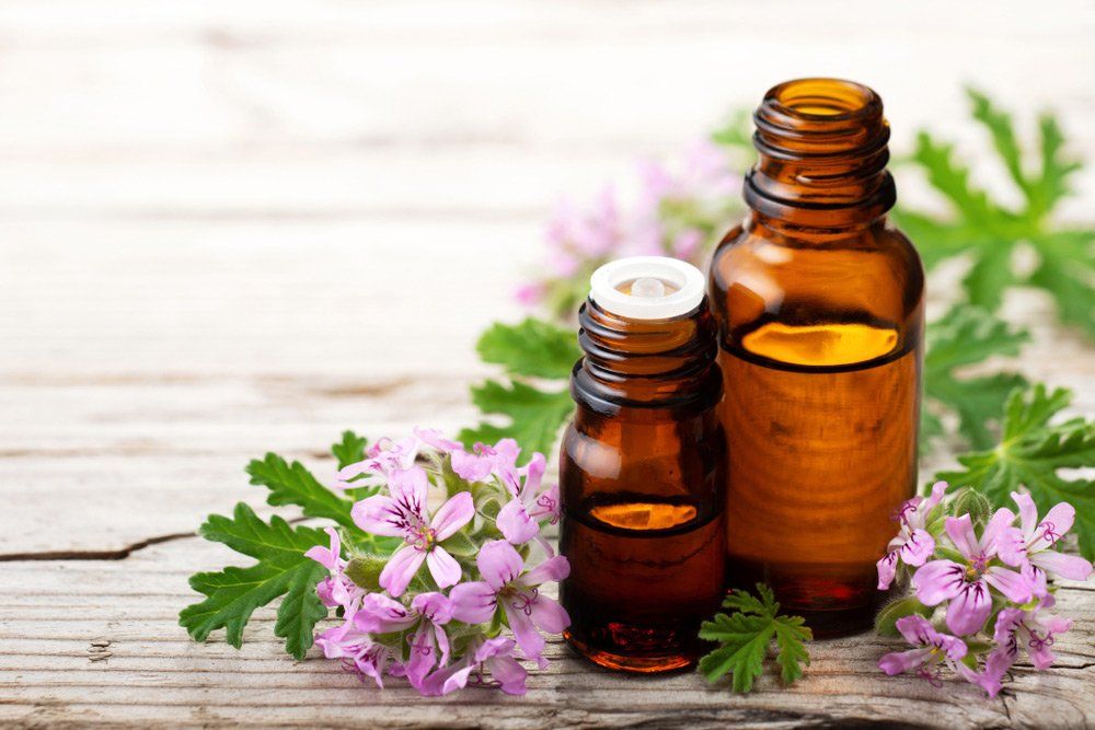 Essential oils with fresh geranium flowers — Holistic Health in Hervey Bay QLD
