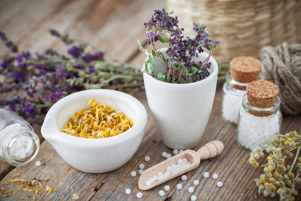 Bowl Of Dried Healing Herbs And Bottles Of Homeopathic Globules — Julie Taylor Naturopath in Hervey Bay, QLD