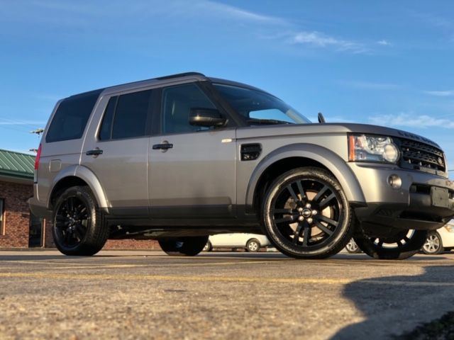 Gray SUV with black wheels parked on pavement under a blue sky