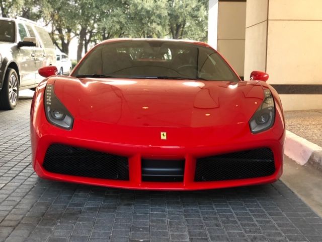 Front view of a red Ferrari parked on a paved driveway