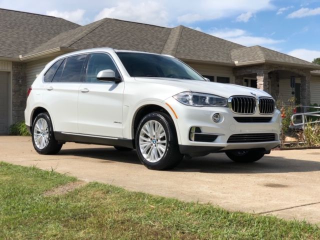 White BMW SUV parked in a driveway in front of a suburban house