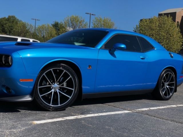 Bright blue sports car parked in a lot under a clear sky