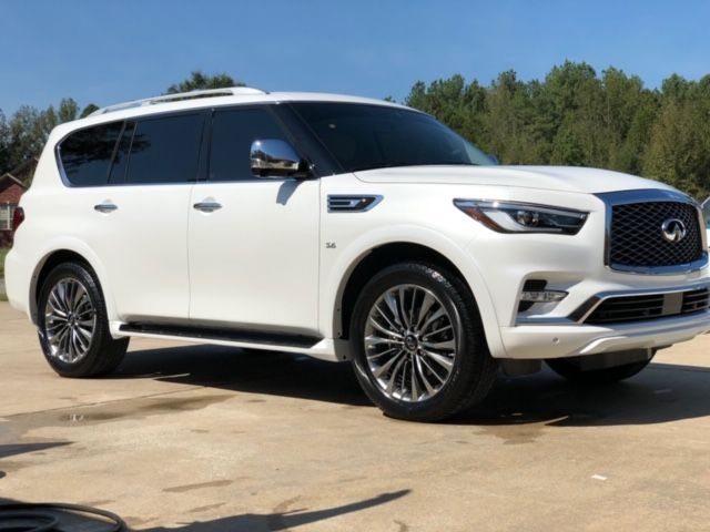 White luxury SUV parked outdoors on a sunny day, shown in side profile.