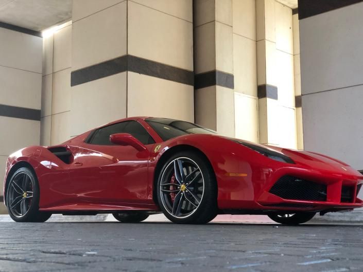 Red sports car parked in a modern building entrance