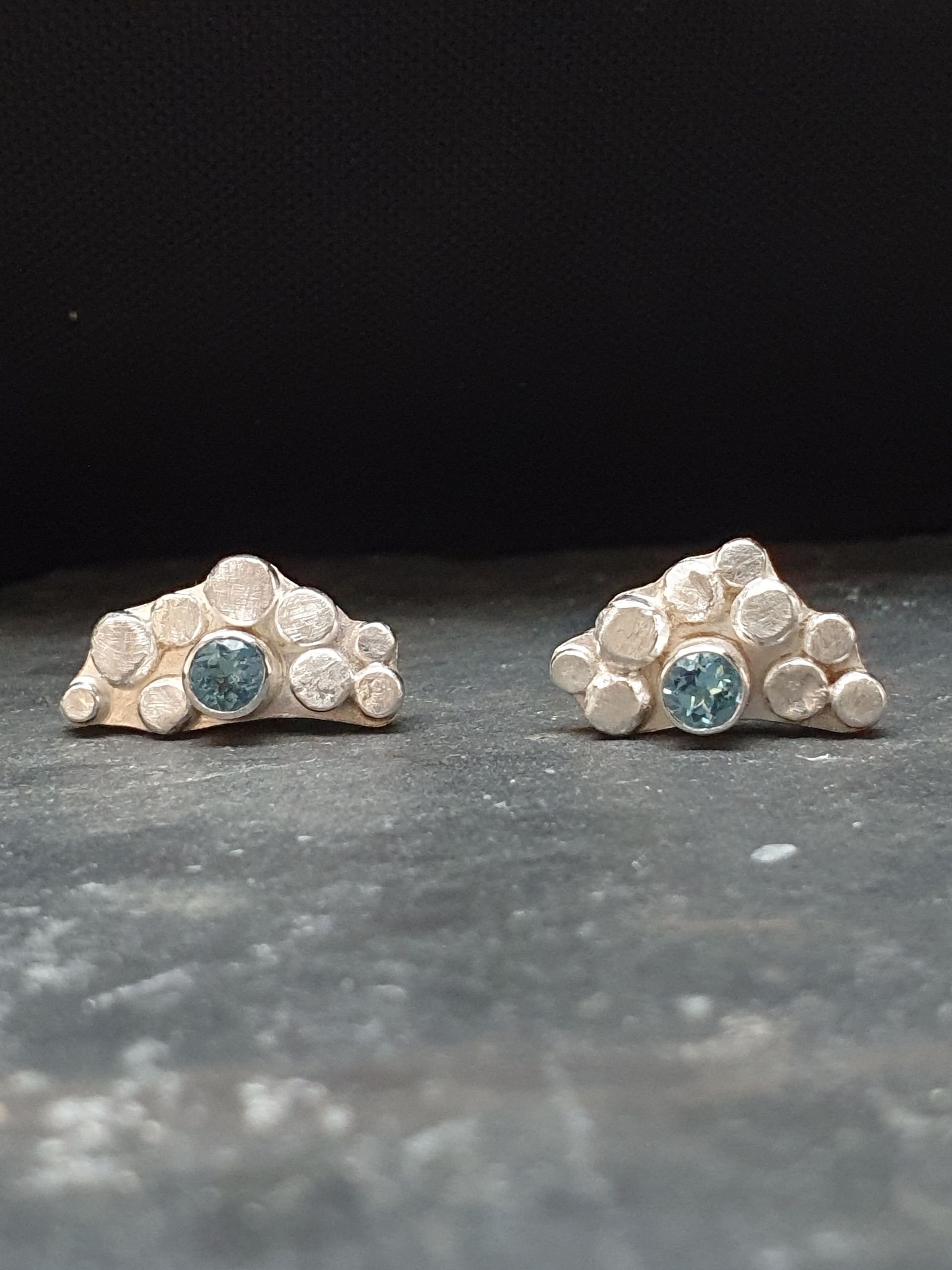 Zilveren oorknopjes met blauwe topaas.
