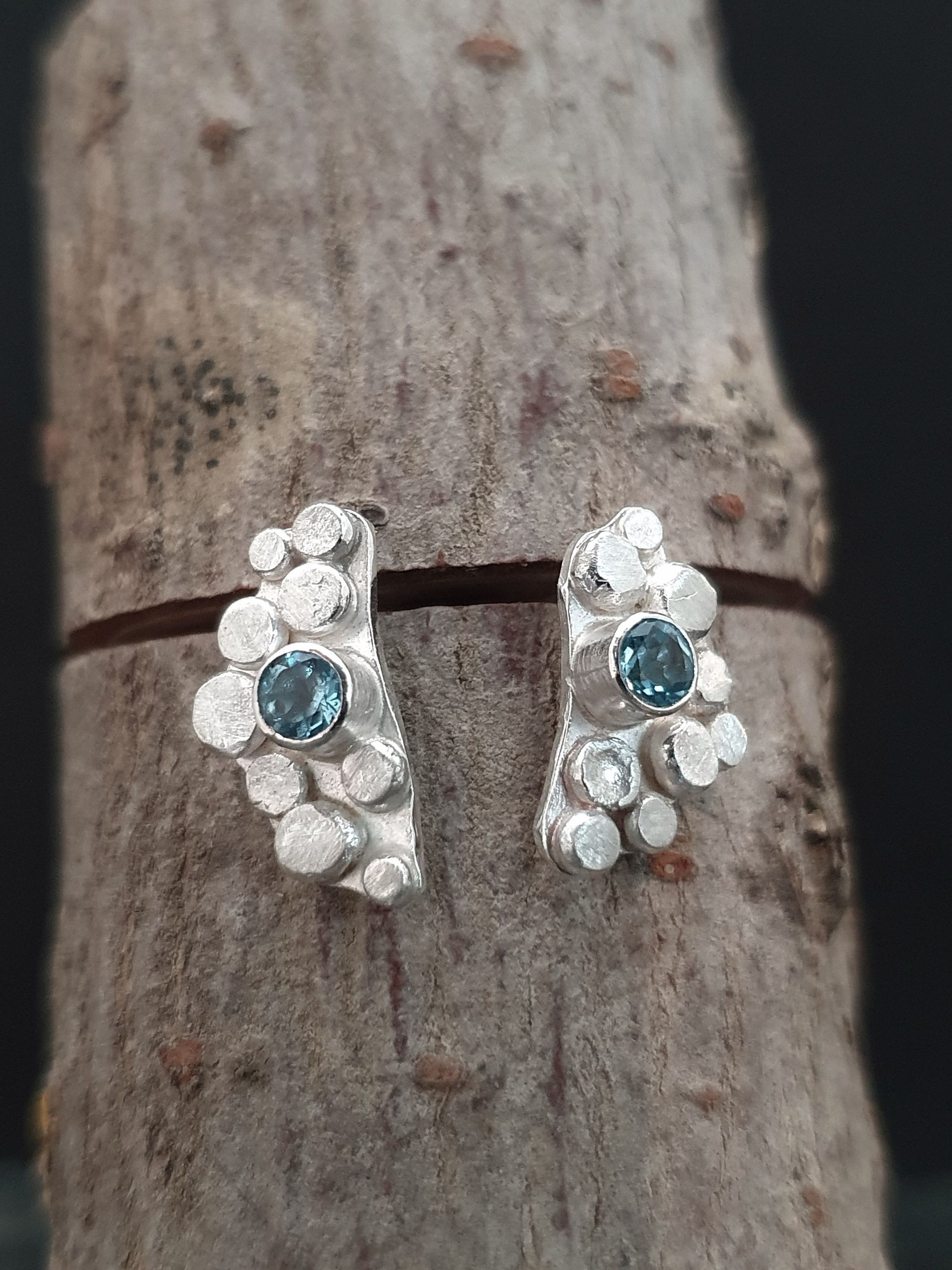 Zilveren oorknopjes met blauwe topaas.