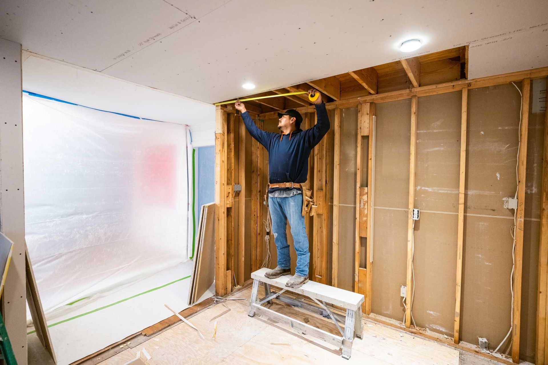 Drywall installers working in kitchen renovation.