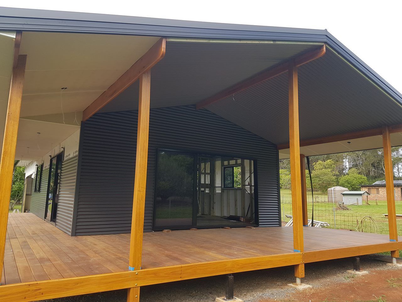 A Man Is Installing Solar Panels On The Roof Of A House — Damn Fine Constructions In Bonville, NSW