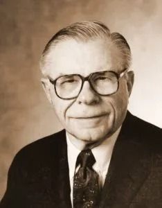 Sepia portrait of Edward L. Benoit in a suit and glasses, facing forward with a slight smile.