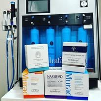 Medical skincare product boxes displayed on a counter beside a blue-lit display case