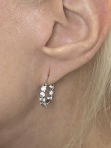 Close-up of an ear wearing a small silver hoop earring