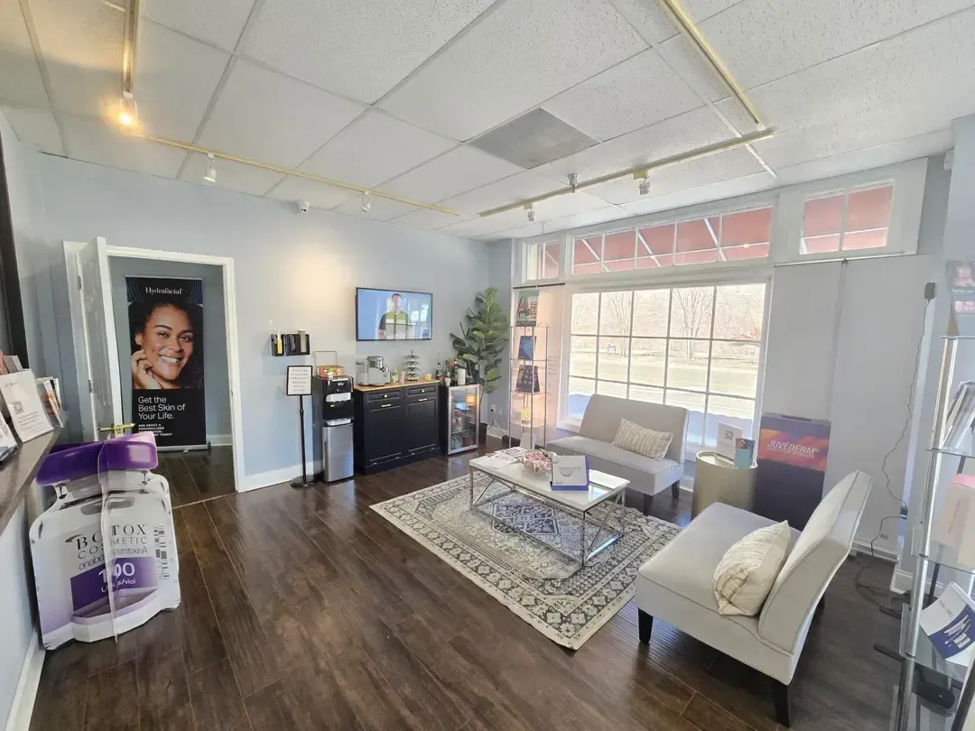 Bright office waiting room with gray chairs, patterned rug, and a large window.