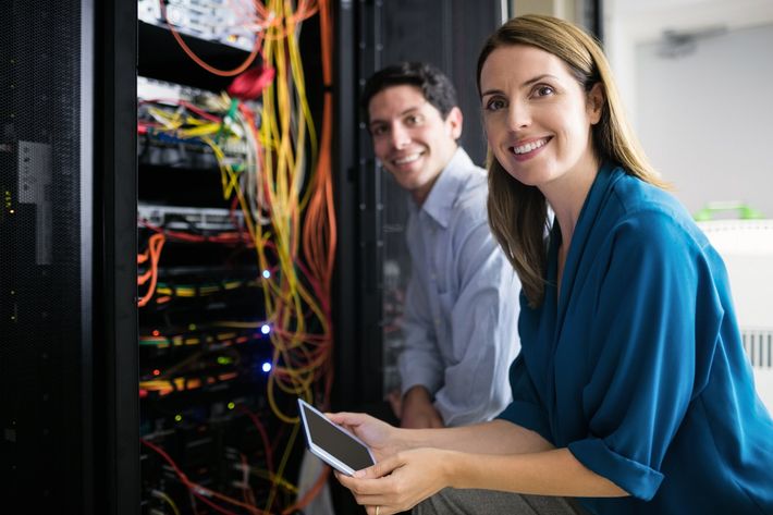 Un homme et une femme travaillent sur un serveur dans un centre de données.