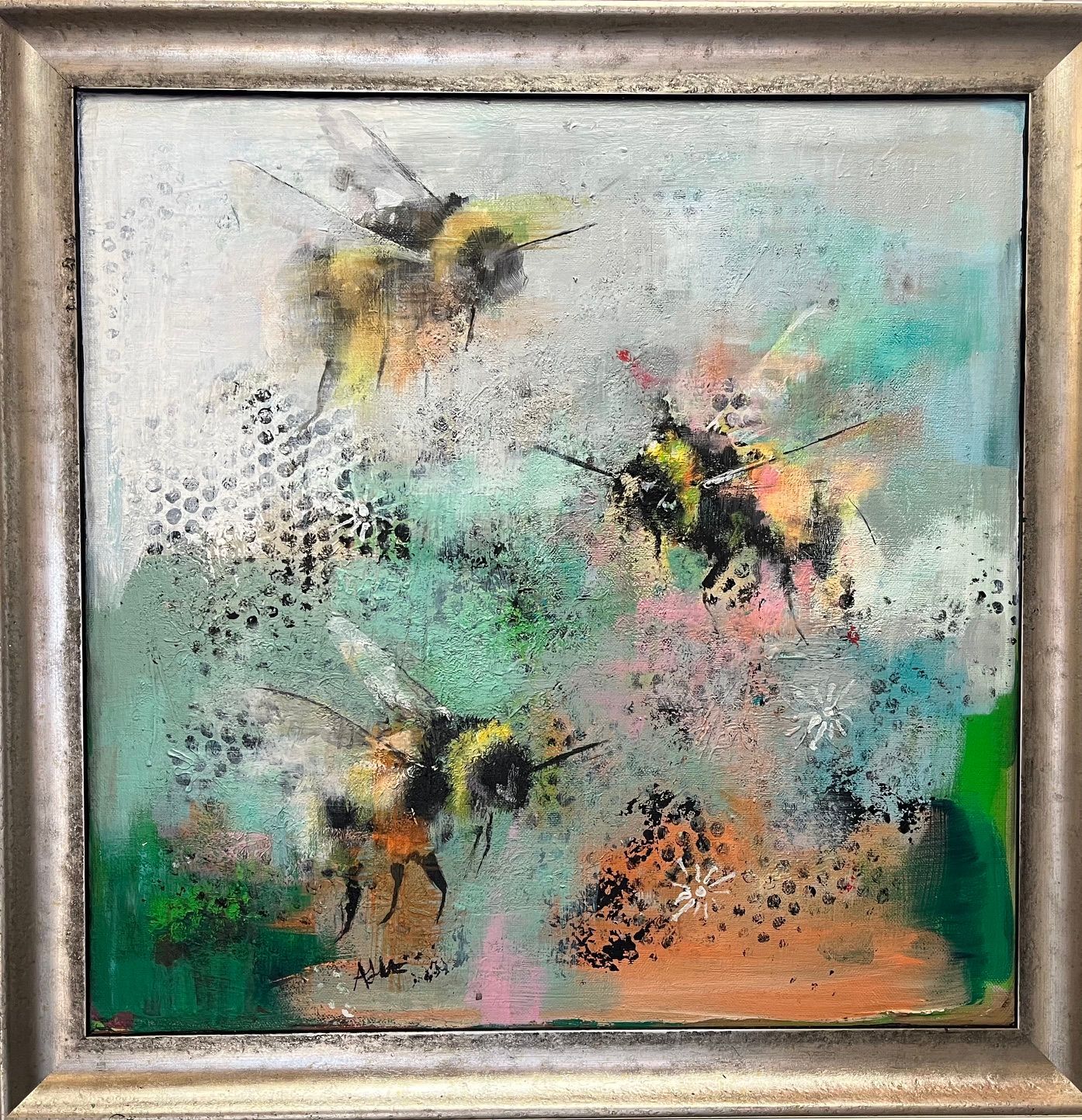 Abstract painting of three bees on a pastel background in a silver frame
