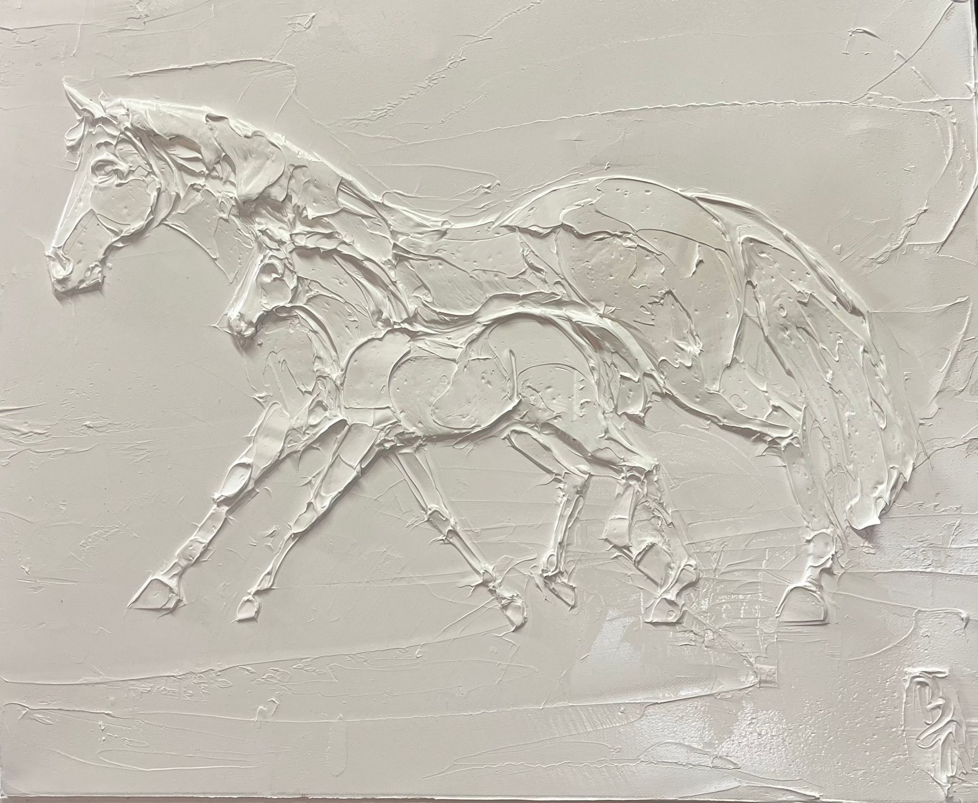 White embossed relief of a galloping horse on a textured wall
