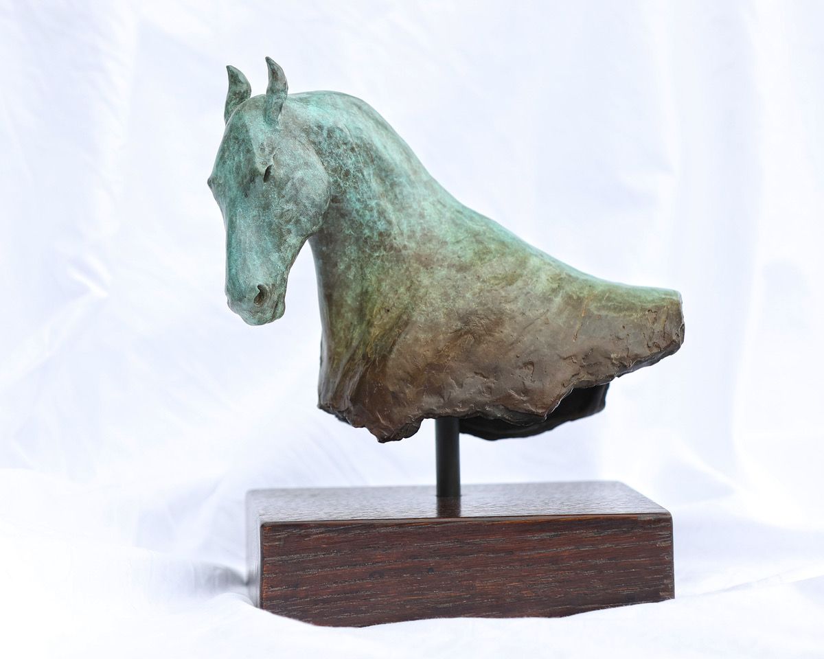 a statue of a horse 's head on a wooden base