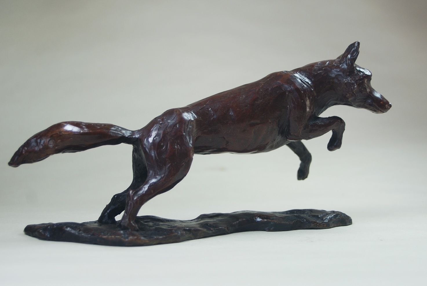 a statue of a fox jumping in the air