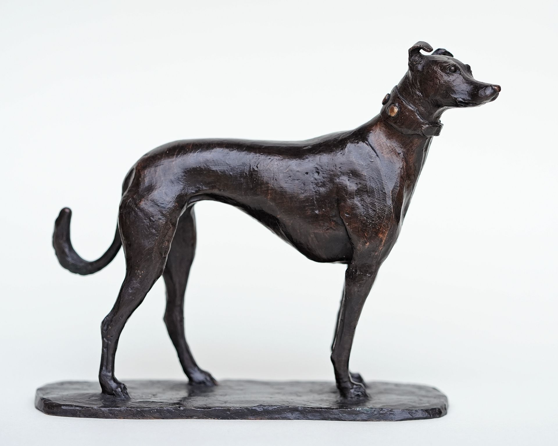 A statue of a dog standing on a white surface