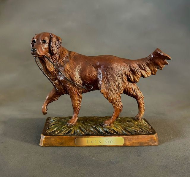 A statue of a brown dog with a chain around its neck