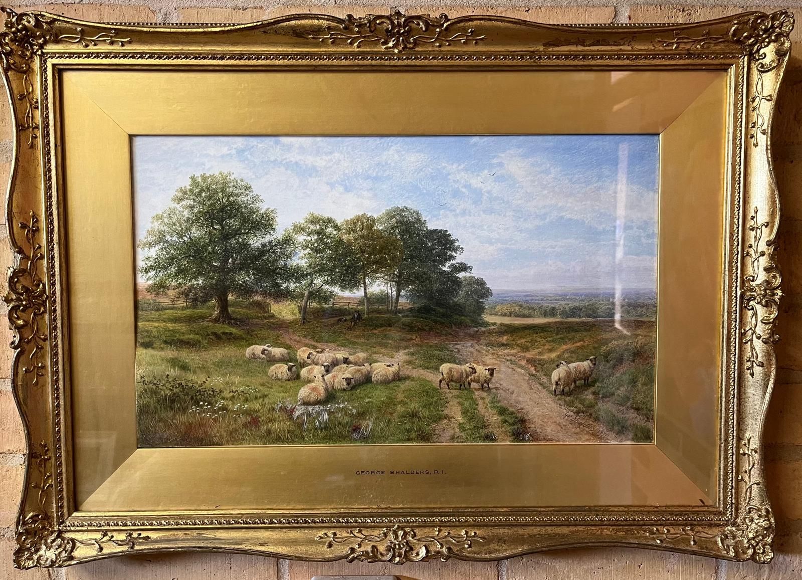 A framed painting of a herd of sheep on a dirt road