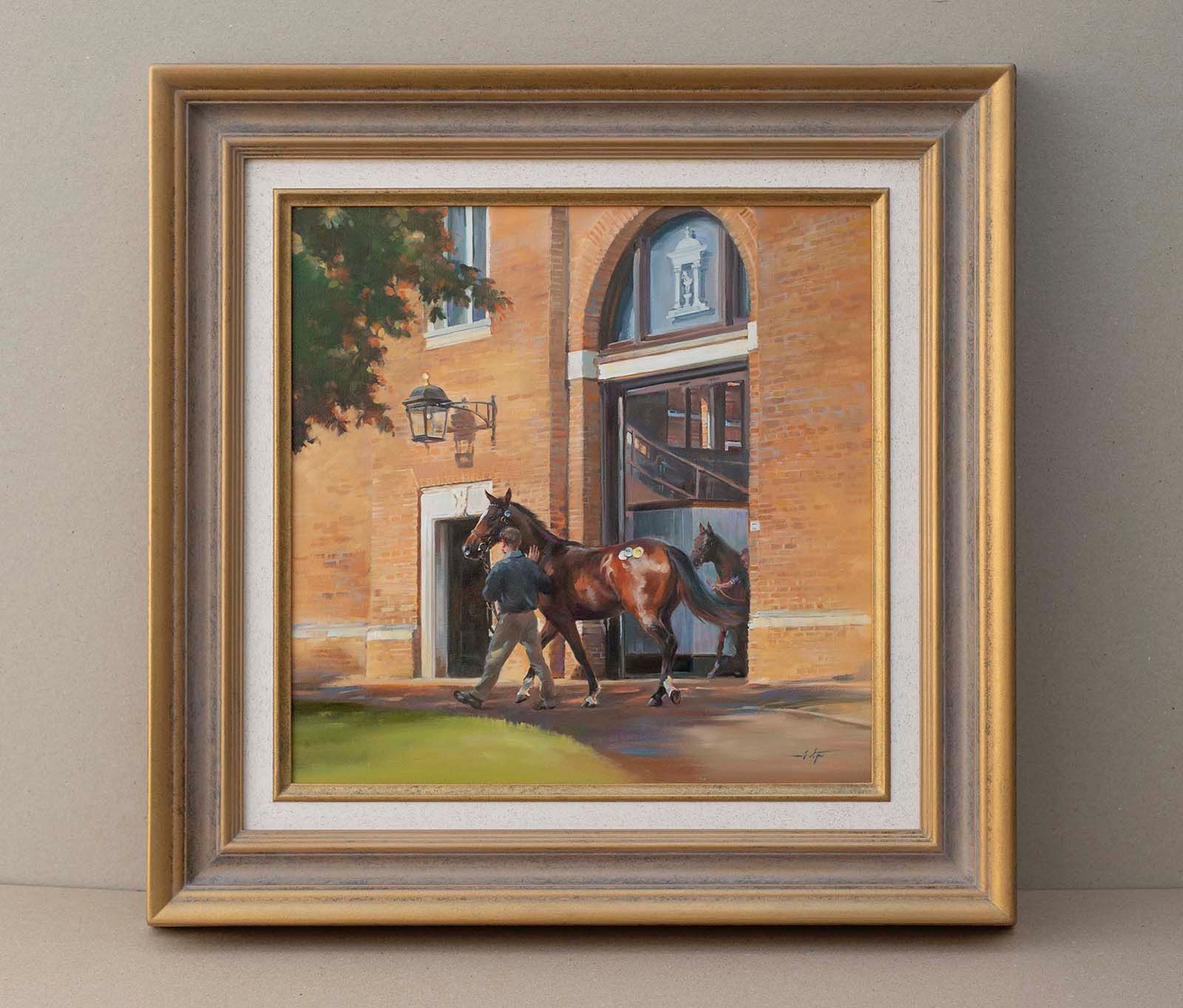 Framed painting of two horses standing beside a brick building with an arched doorway.