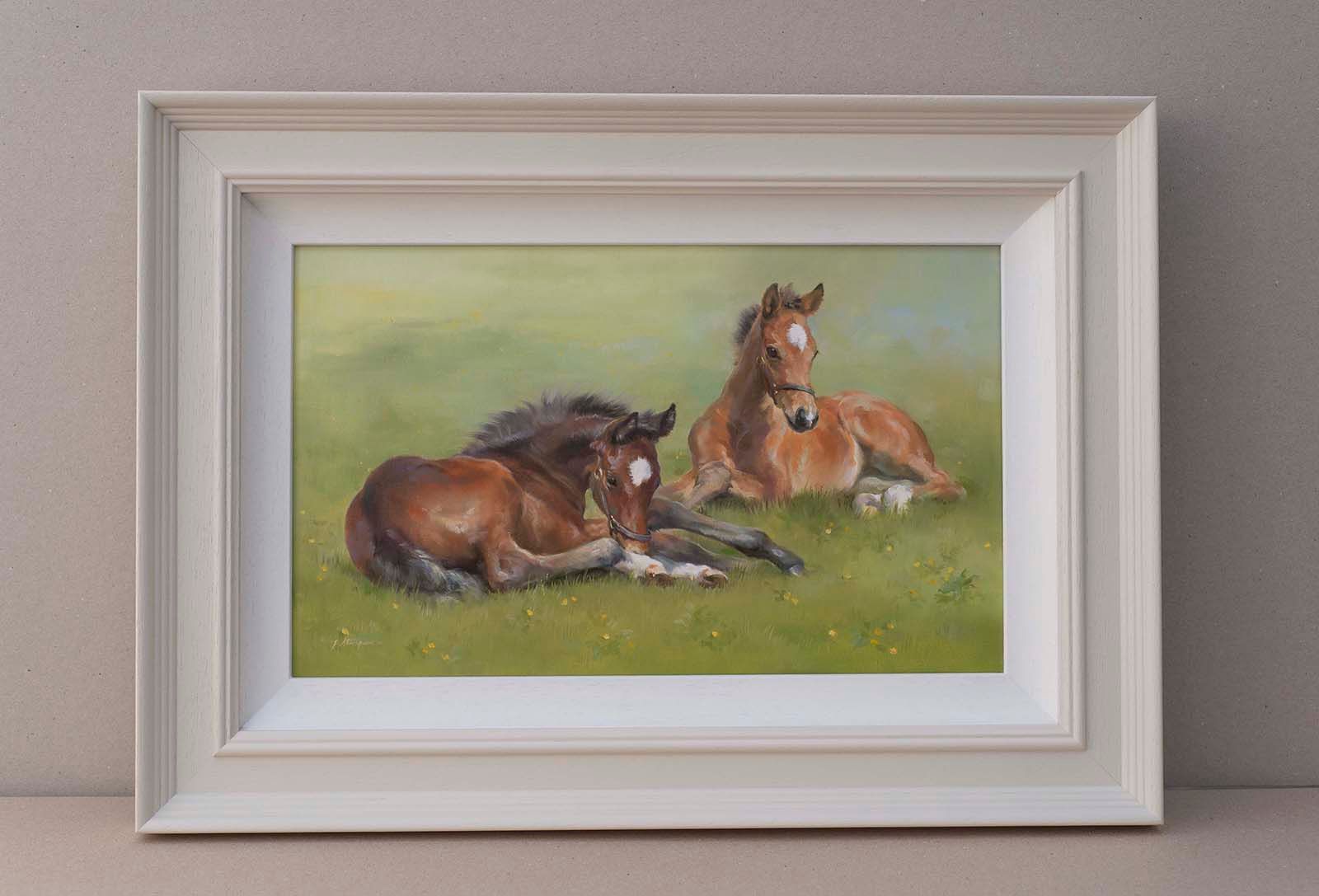 Framed painting of two brown horses resting in a green field