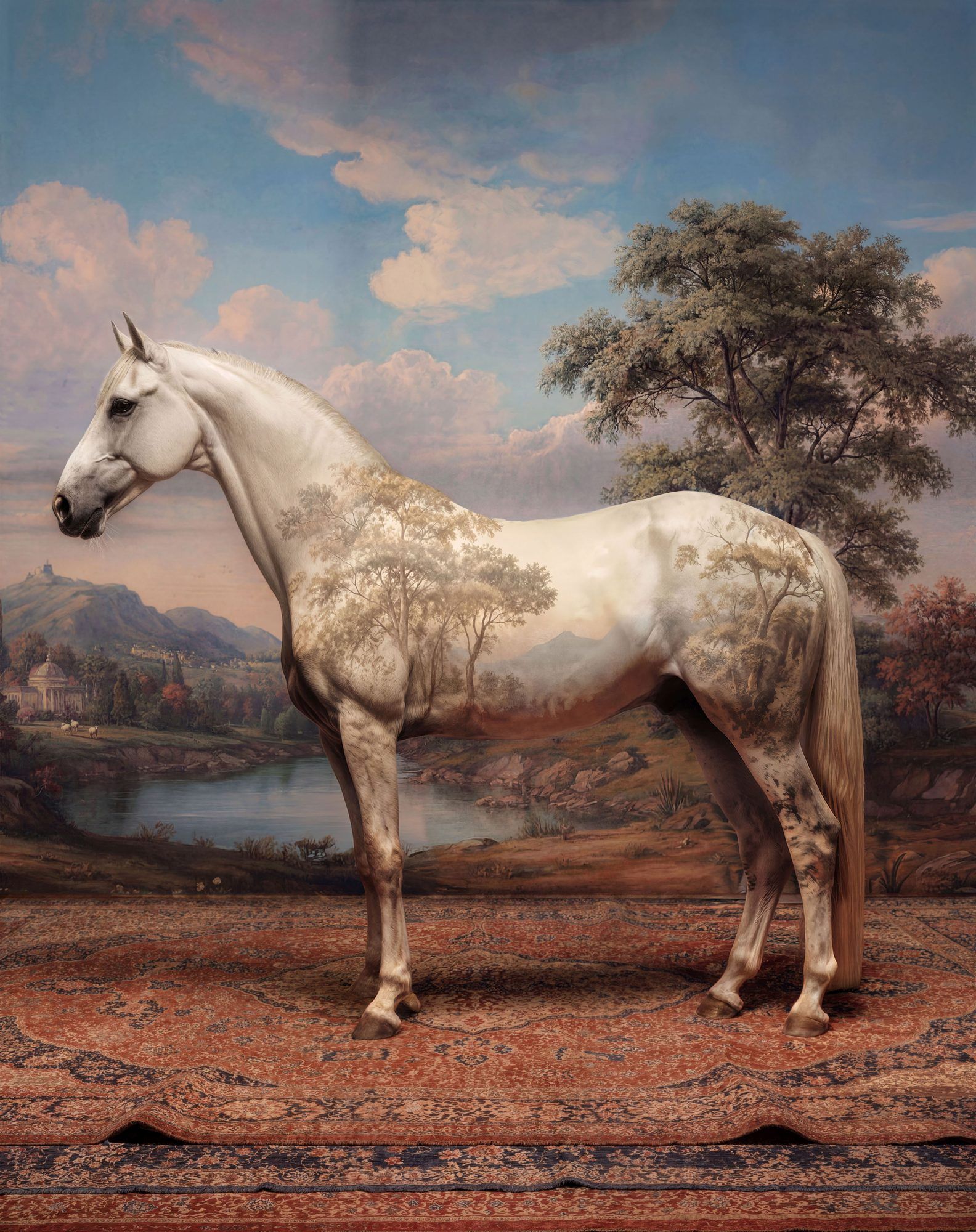 White horse standing on a patterned rug in a painted landscape with trees and a cloudy sky
