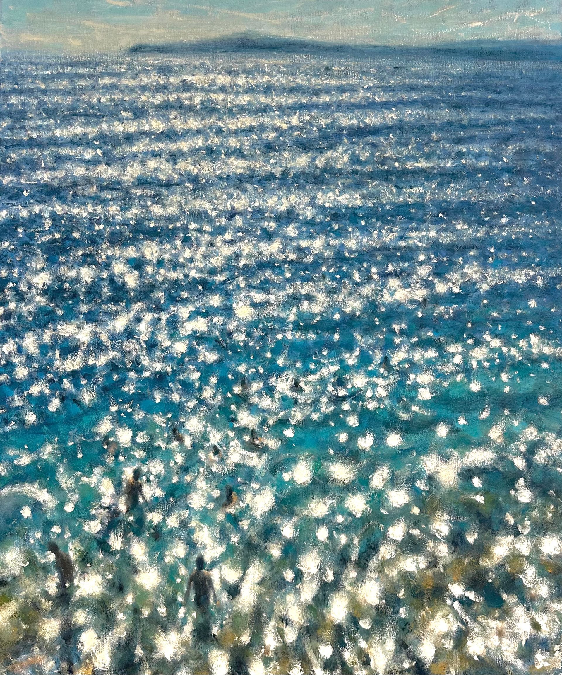 Sunlight sparkles across a blue ocean surface with gentle waves