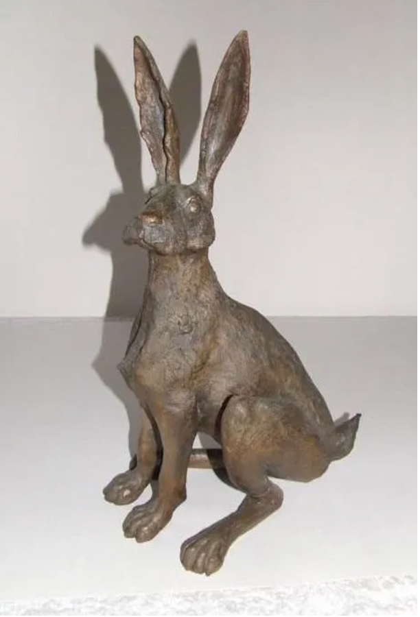 a bronze statue of a rabbit sitting