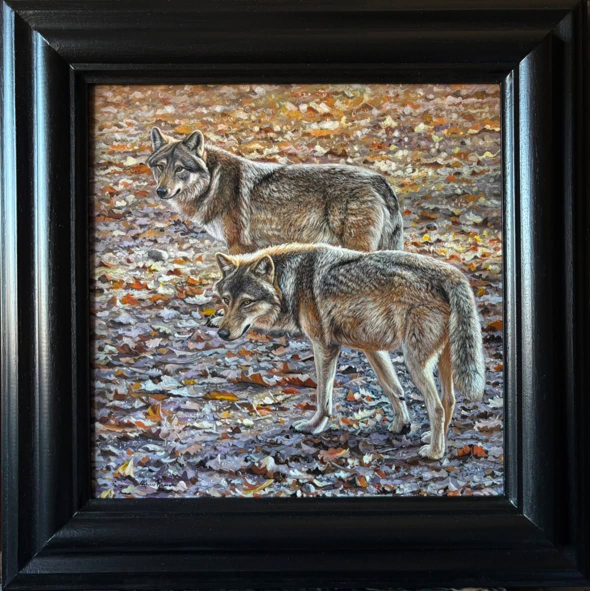 Framed painting of two wolves standing on a rocky, autumn-colored ground