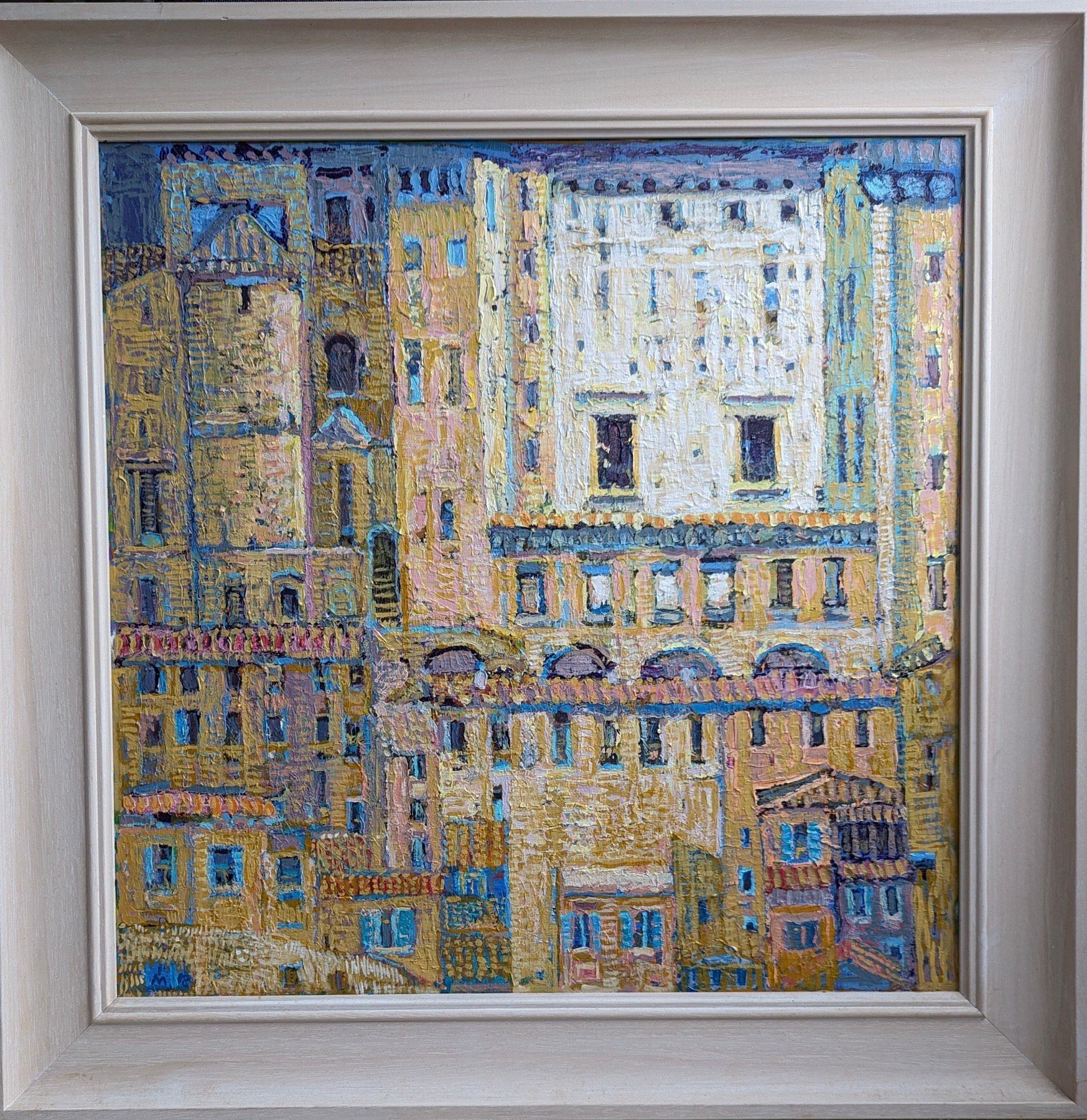 A framed painting of a city with lots of buildings