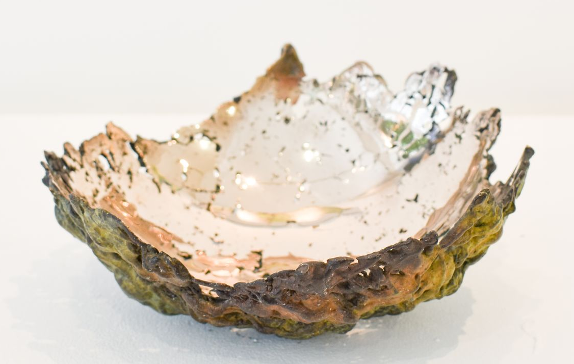 A small decorative shell-shaped bronze bowl with iridescent pink and white interior on a white background