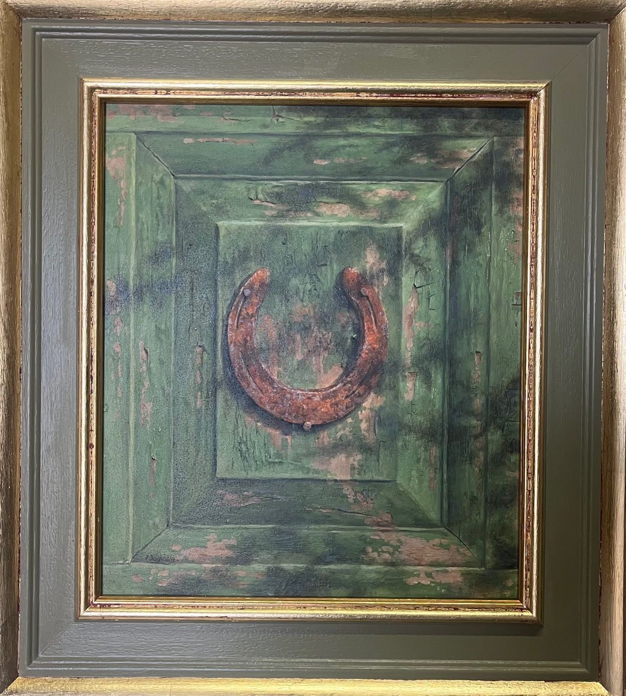 Green, square artwork. A rusty horseshoe hangs on a weathered green surface, framed in gold and green.