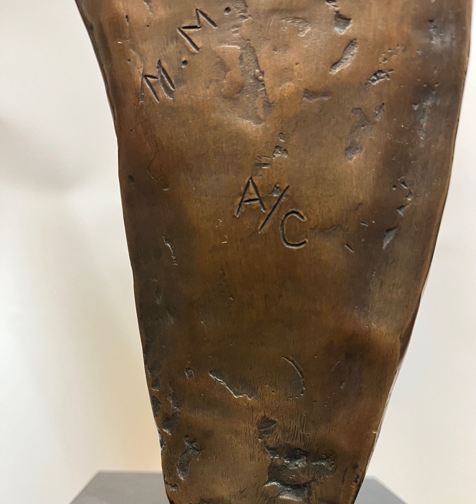 Bronze sculpture, close-up of base with etched initials 
