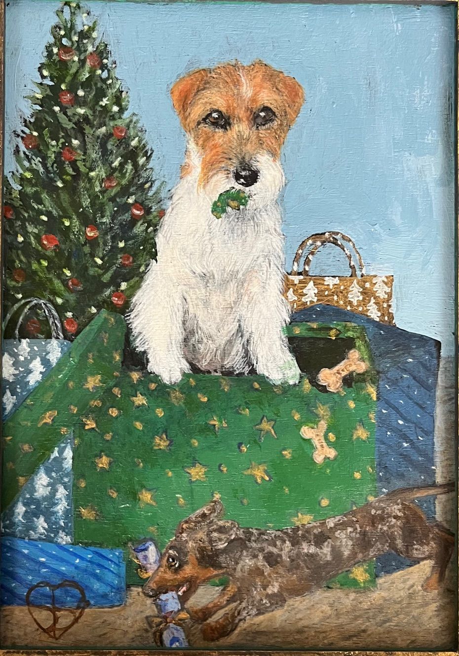 Dog sitting in a Christmas present, another dog playing nearby. Christmas tree and gifts in the background.