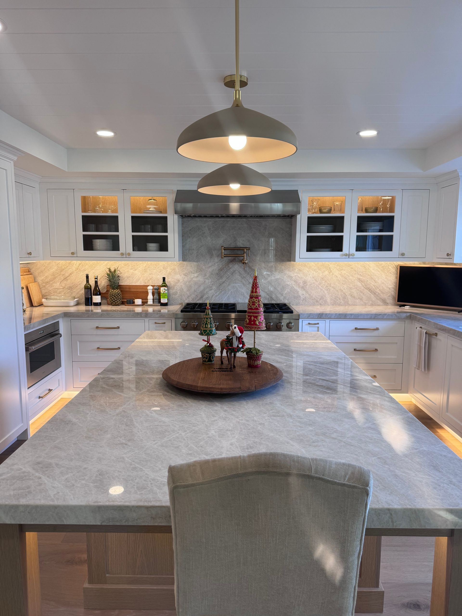 Bright modern kitchen with gray island, white cabinets, and holiday centerpiece on the countertop
