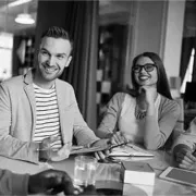 A black and white photo of a group of people sitting at a table.