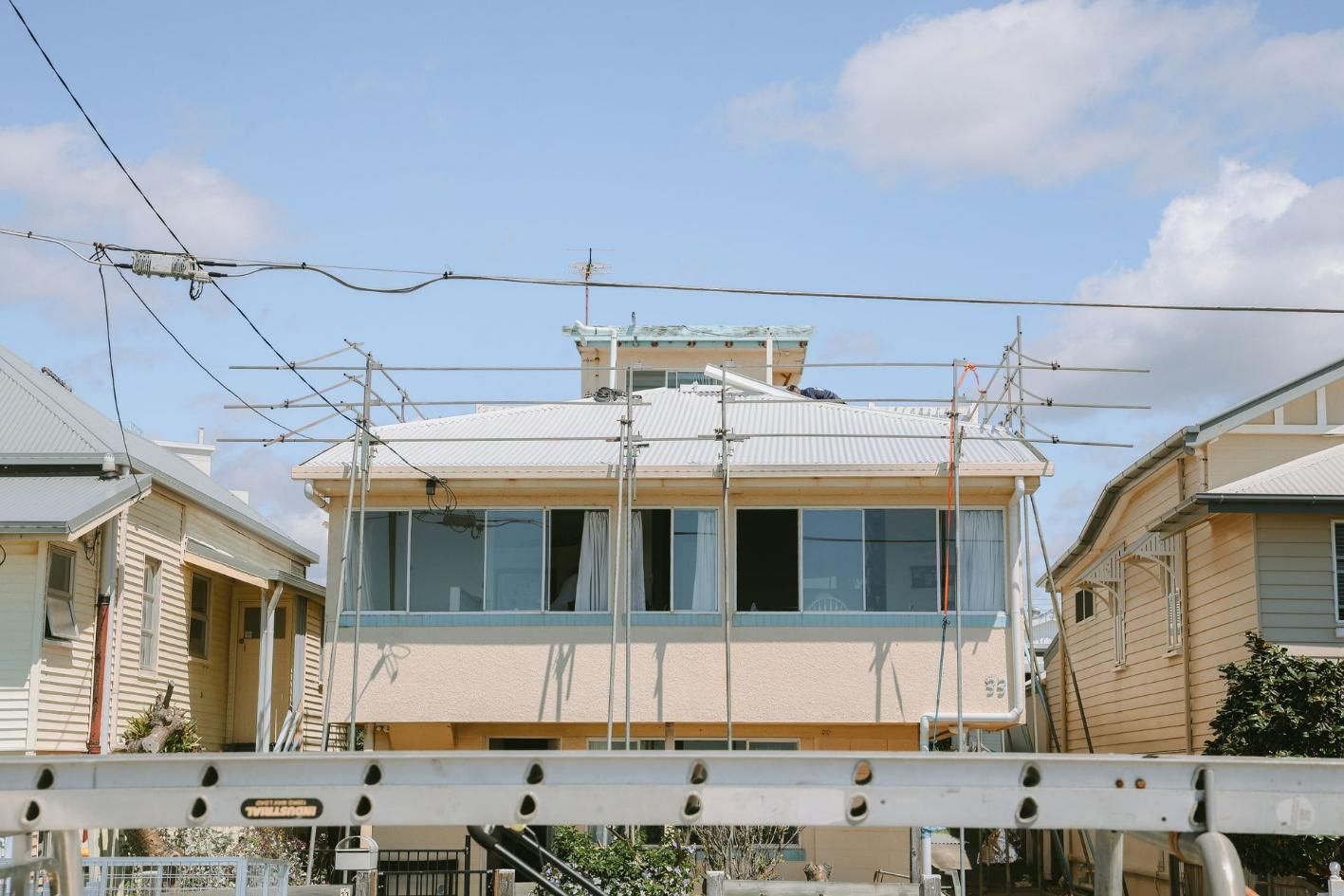 Large House With Scaffolding on the Roof — Beards Roofing and Plumbing in Clontarf, QLD