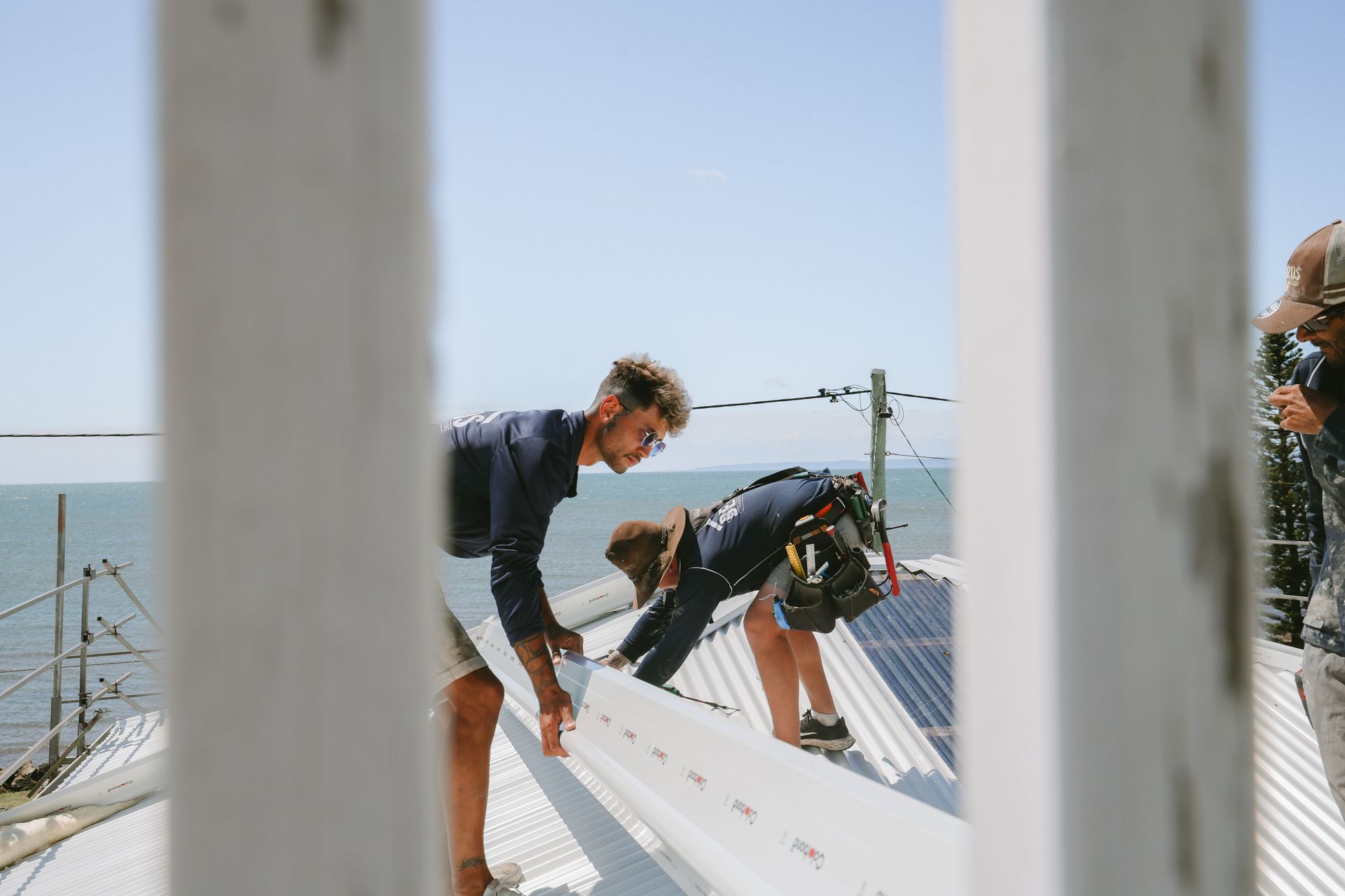 Two Men Are Working on the Roof of a Building — Beards Roofing and Plumbing in Clontarf, QLD