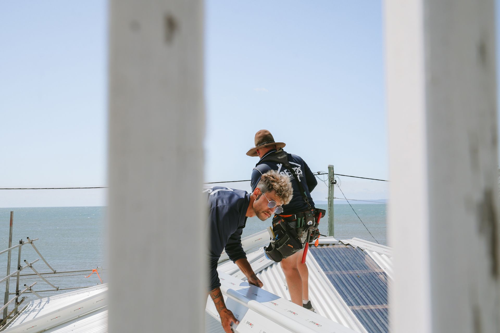 A Man Installing White Colorbond Roofing — Beards Roofing and Plumbing in Morayfield, QLD
