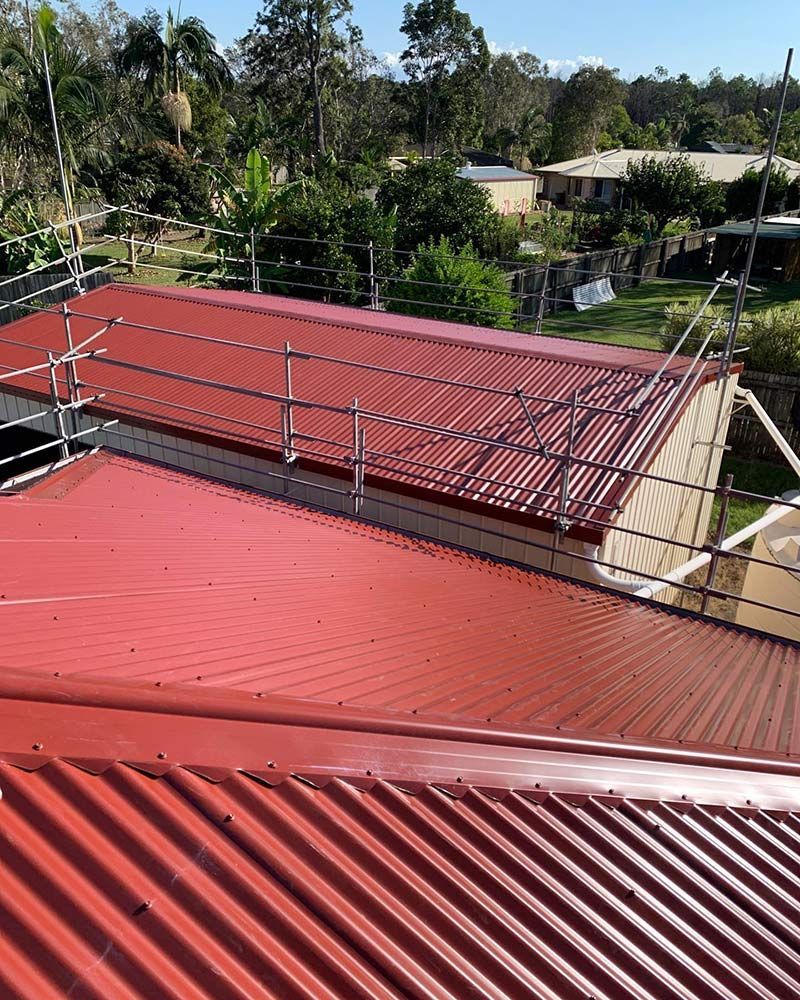 A Red Roof With a Metal Railing on Top of It — Beards Roofing and Plumbing in Brisbane, QLD