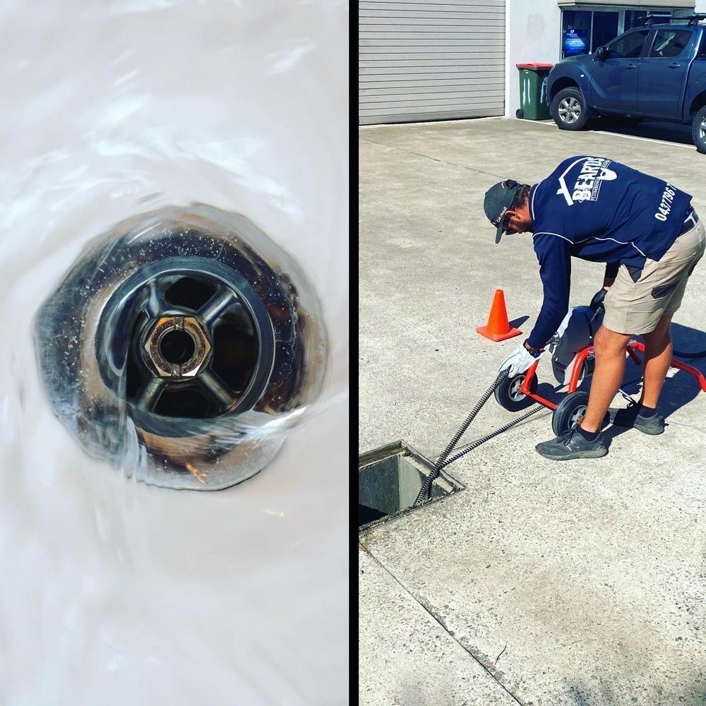 A Man is Cleaning a Drain With a Hose — Beards Roofing and Plumbing in North Lakes, QLD