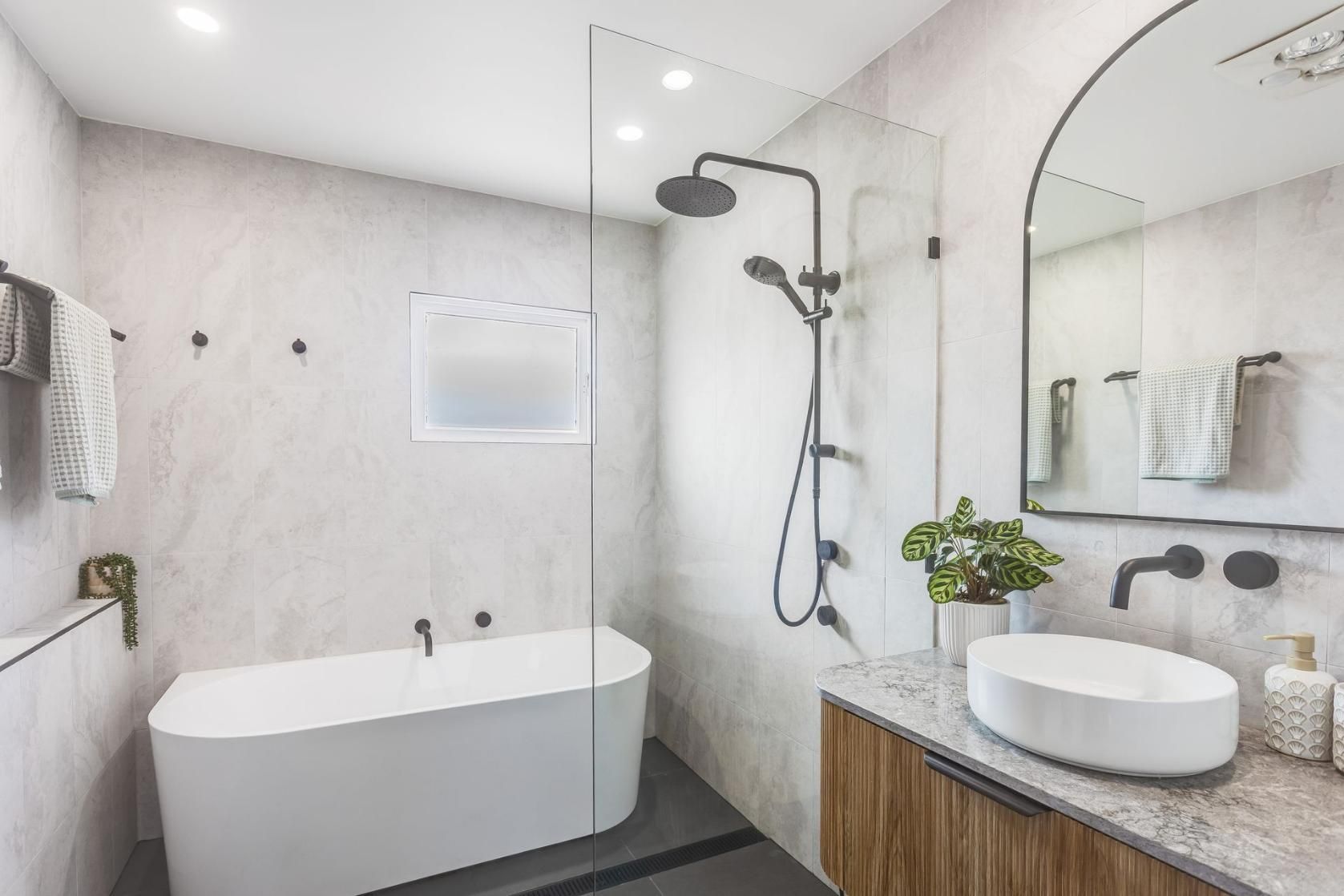 Bathroom With a Bathtub, Sink, Shower and Mirror — Beards Roofing and Plumbing in Clontarf, QLD