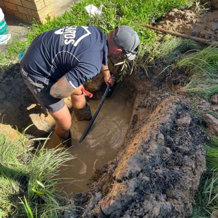 Man is Digging a Hole in the Dirt With a Shovel — Beards Roofing and Plumbing in Clontarf, QLD