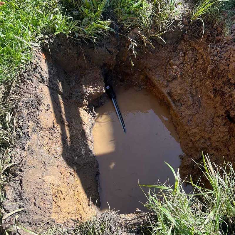 A Hole in the Ground With a Hose Sticking Out of It — Beards Roofing and Plumbing in North Lakes, QLD