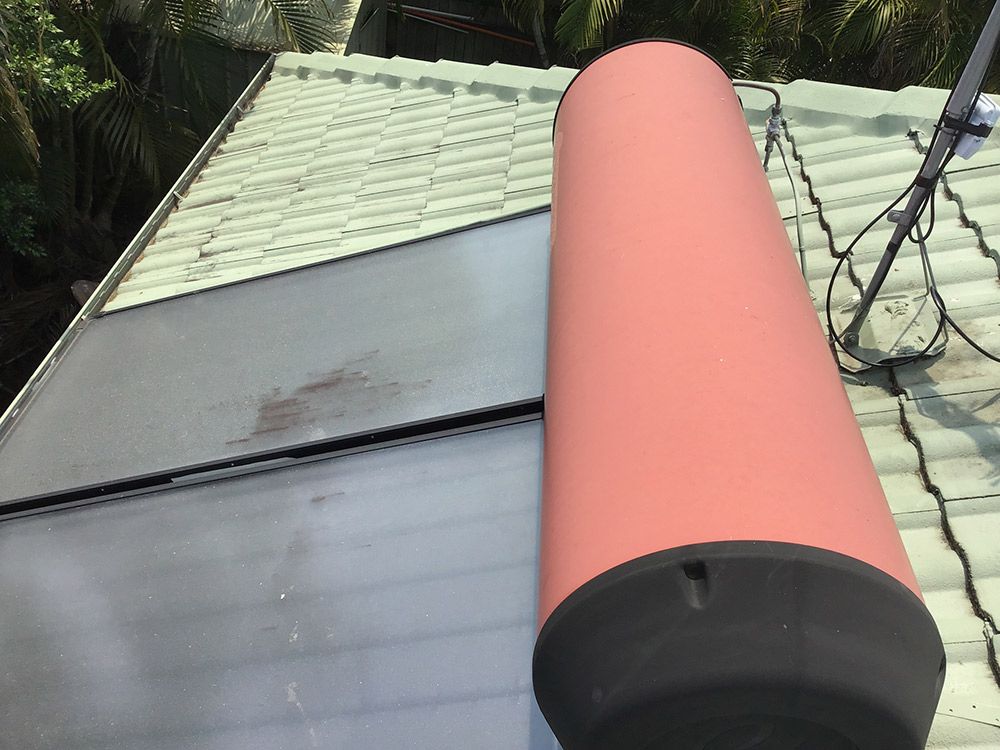 A Red Cylinder is Sitting on Top of a Roof — Beards Roofing and Plumbing in Caboolture, QLD