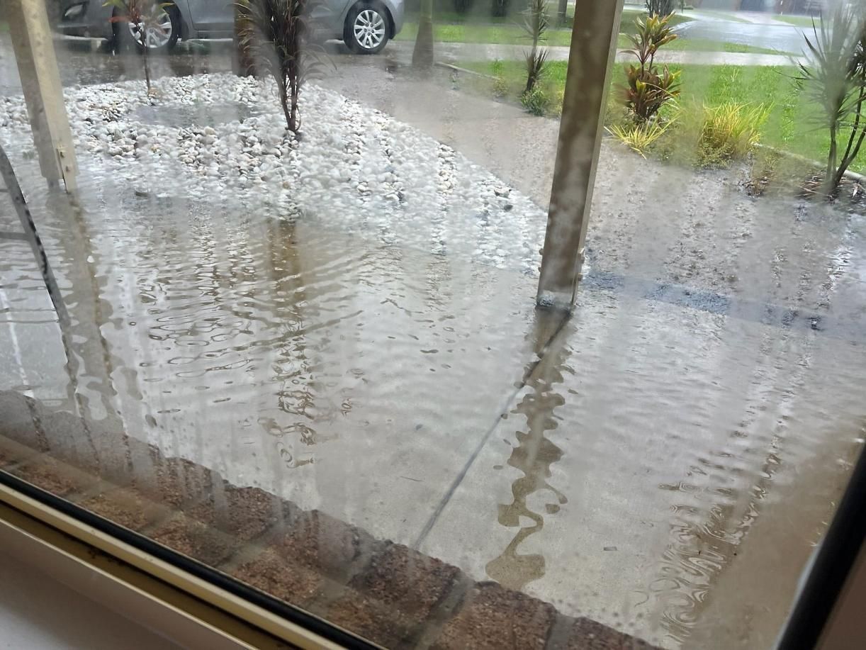 Window With a View of a Flooded Driveway — Beards Roofing and Plumbing in Clontarf, QLD