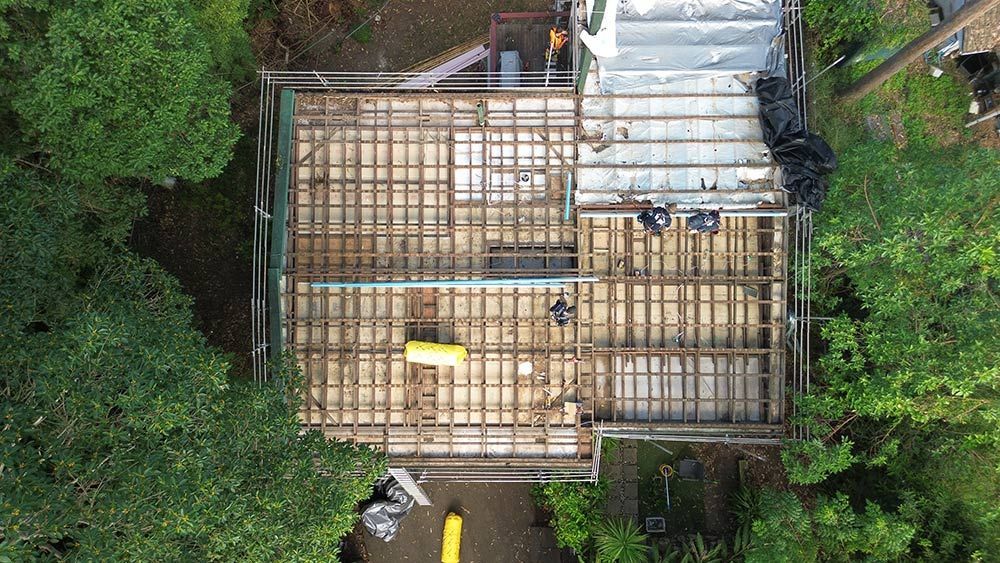 An Aerial View of a House Under Construction Surrounded by Trees — Beards Roofing and Plumbing in Redcliffe, QLD